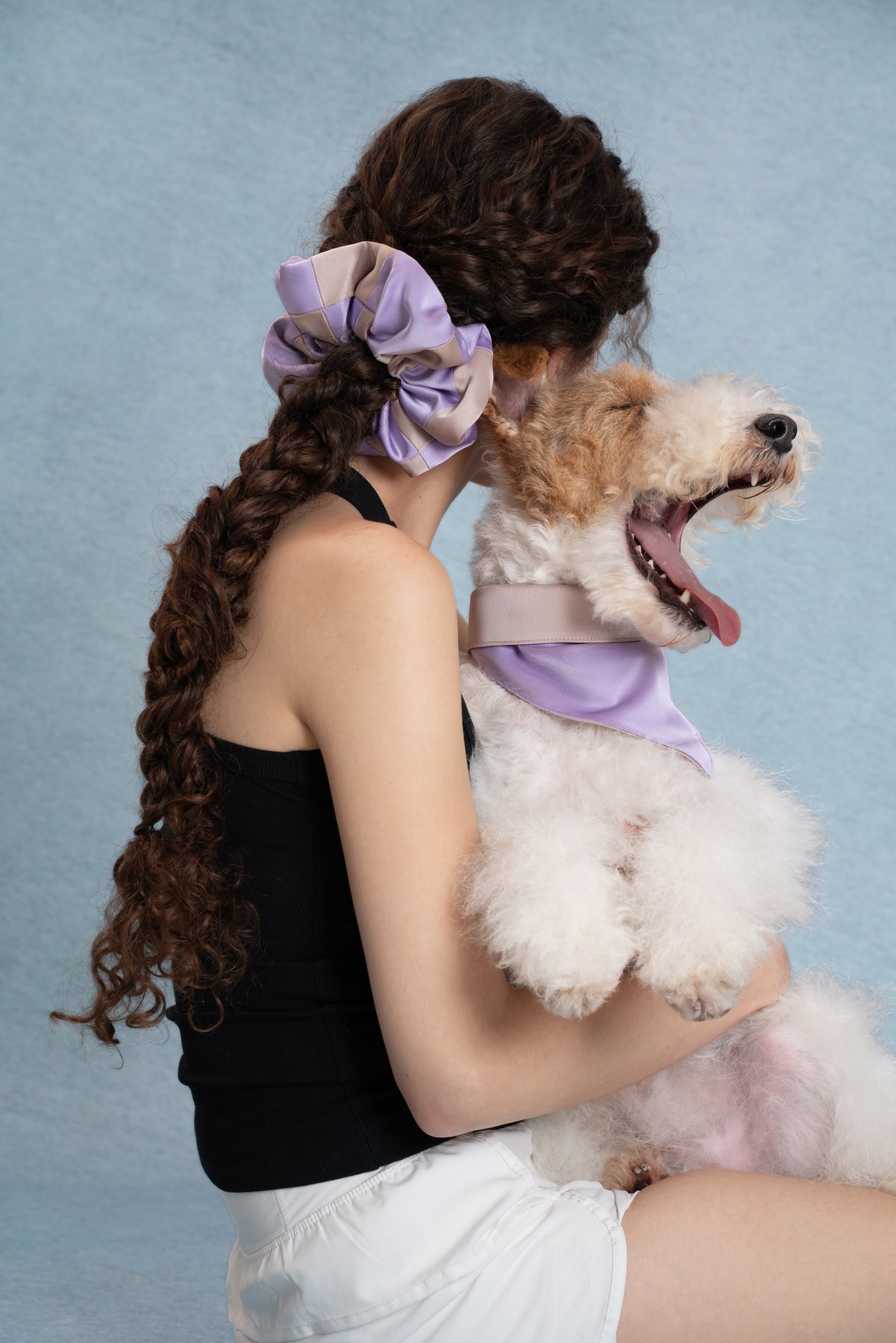 Woman and dog wearing a Lavender Mist matching set against the blue studio background